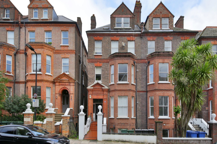Exterior of a red brick Victorian terraced property across multiple storeys